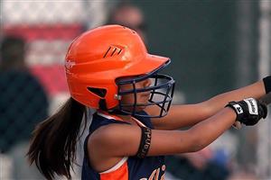 Young softball player mid-swing.